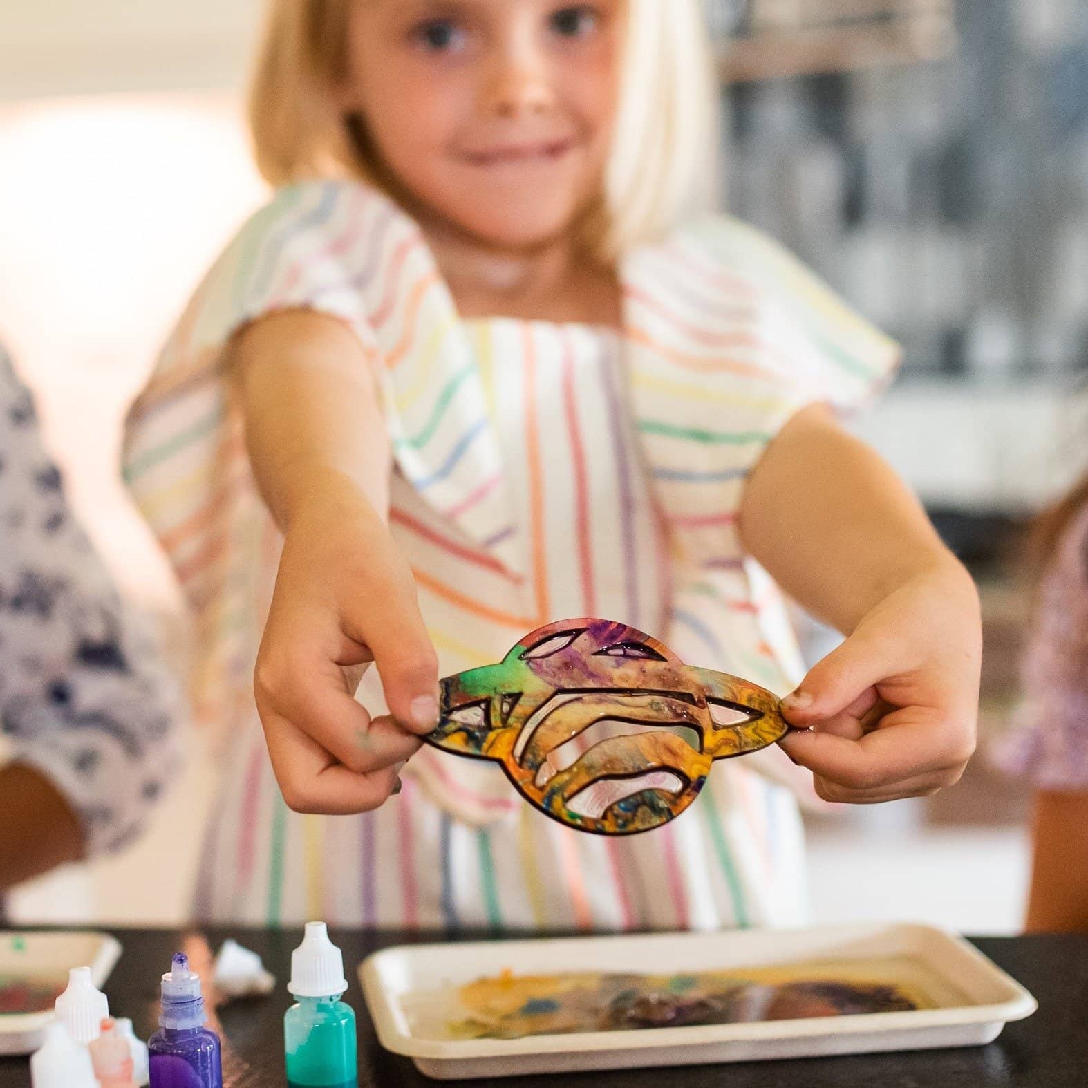 Child proudly showing finished marbled Saturn.